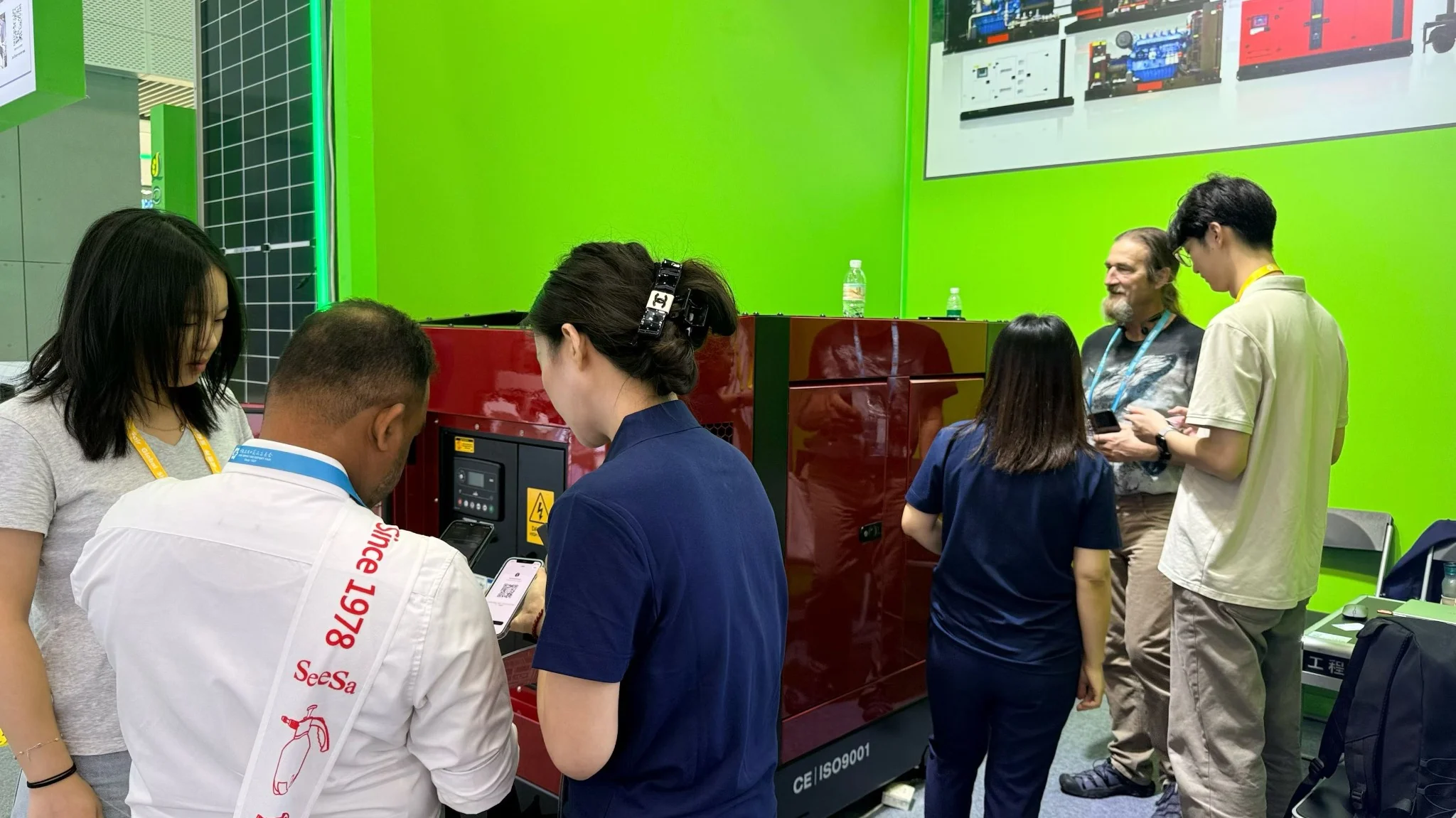 GOODWIND staff speaking with visitors beside a generator set at the Canton Fair