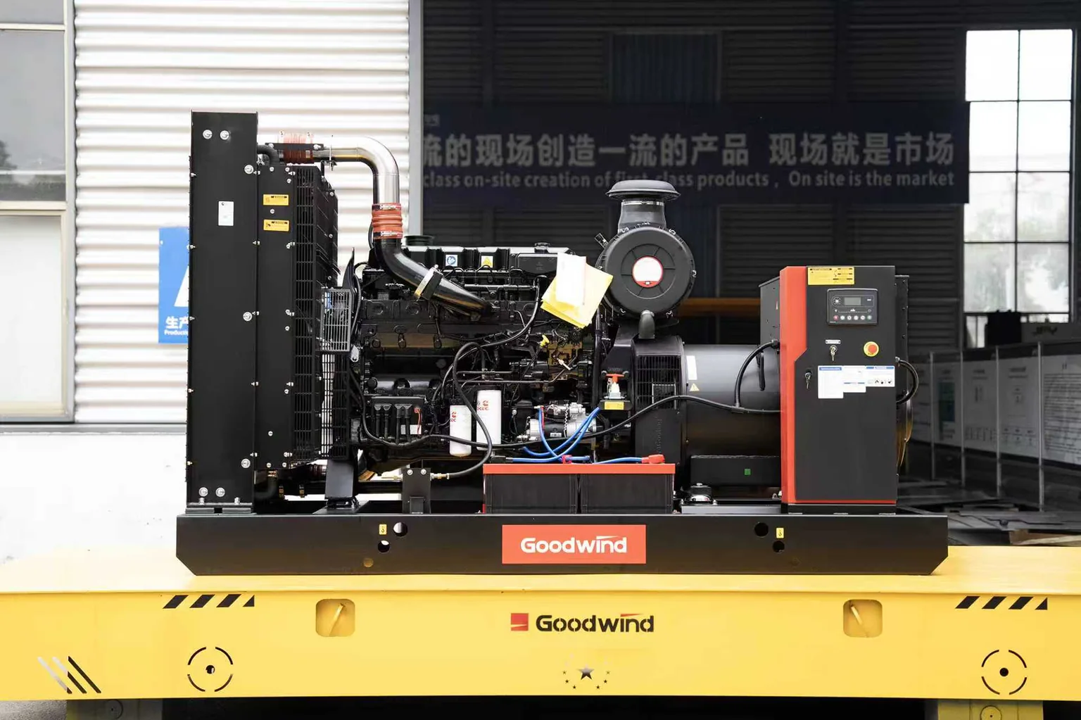 Open generator set with a radiator on the left, engine and alternator in the centre, and a control cabinet on the right